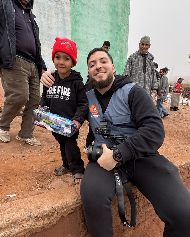 Nabil met zijn camera en een jongen met een rode muts tijdens een project in Marokko